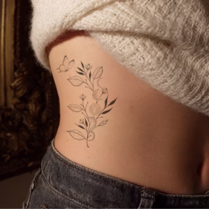 Minimalist black and white tattoo of botanical branches with moon phases inked on ribs in fine line and dotwork style